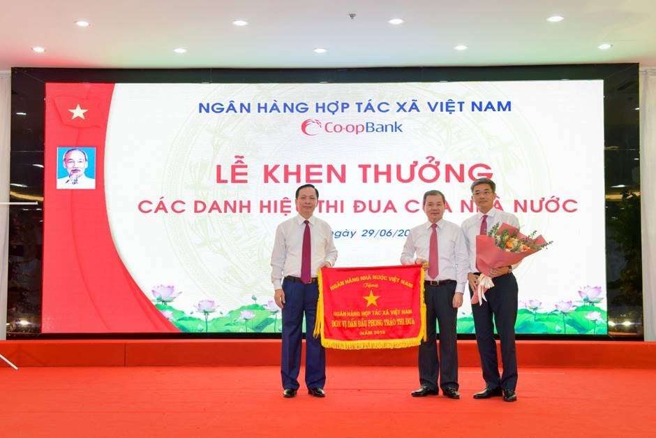 Phó Thống đốc Thường trực NHNN Đào Minh Tú trao Cờ thi đua của NHNN cho NHHT